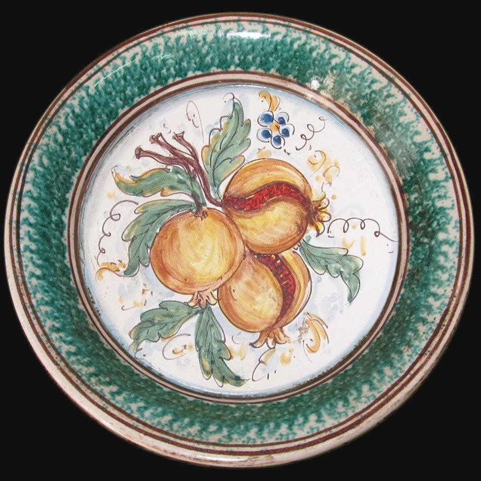 Piatto in ceramica di Caltagirone fatta a mano con motivi di melograni e foglie verdi