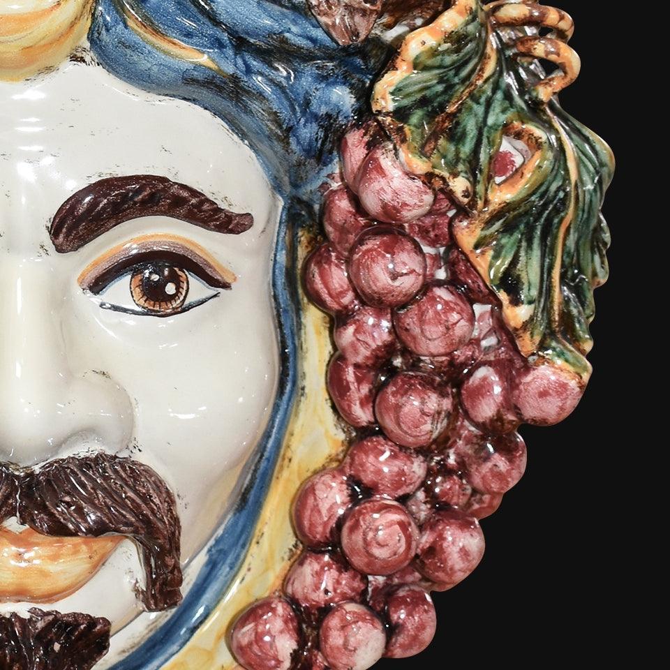 Ceramiche di Caltagirone fatti a mano con dettaglio volto e grappolo d'uva, arte tradizionale siciliana